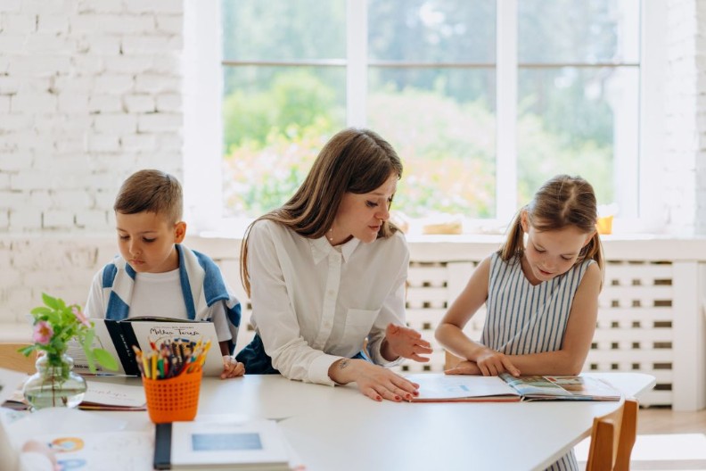 Voorlezen; vrouw leest voor aan twee kinderen